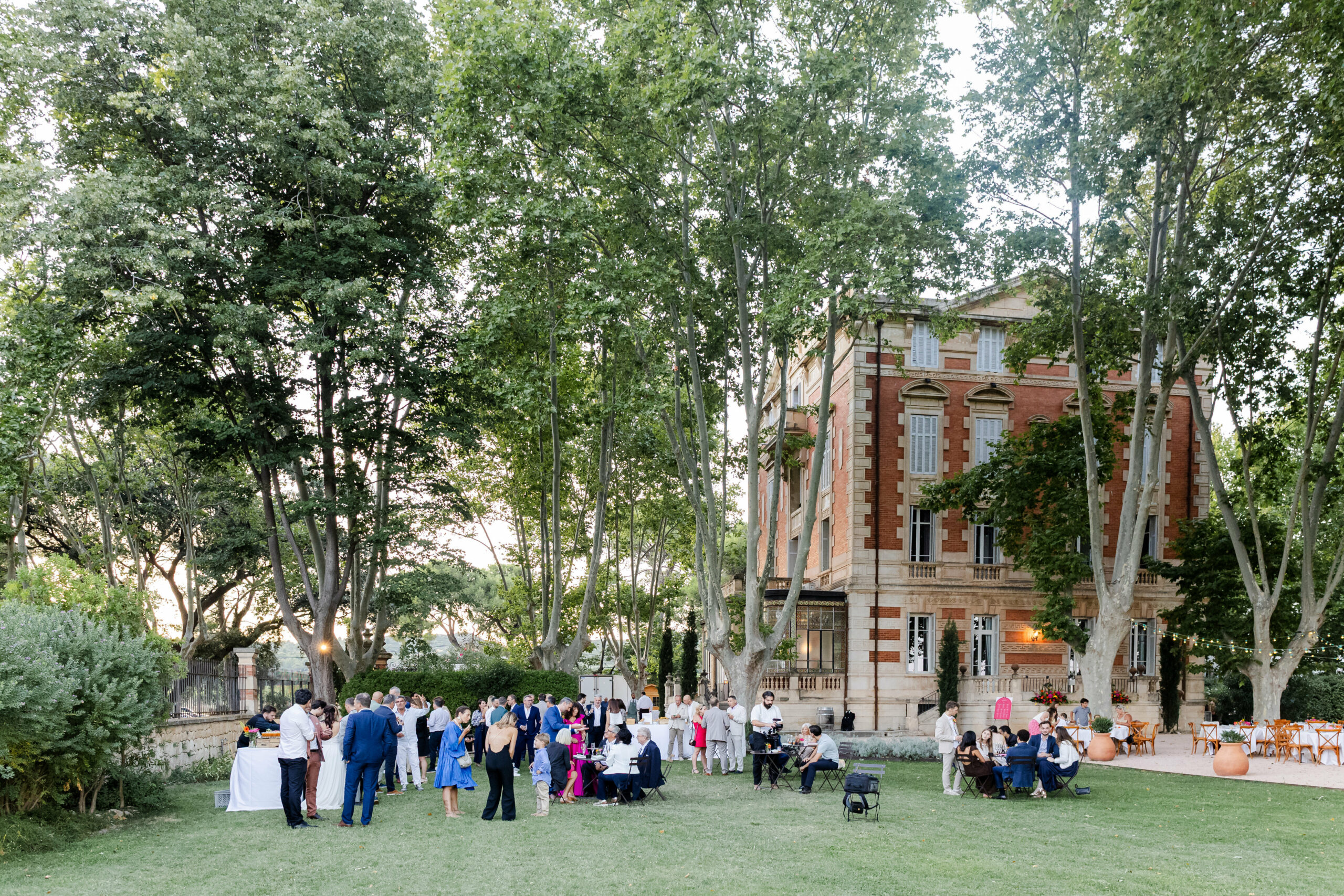 Cocktail de mariage organisé devant le Château La Beaumetane en Provence, invités profitant du cadre extérieur élégant et convivial